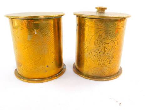 A pair of WWI trench art tobacco jars and covers formed from German shell cases, of cylindrical form with engraved decoration, dated 1917 and 1918, 10cm high.