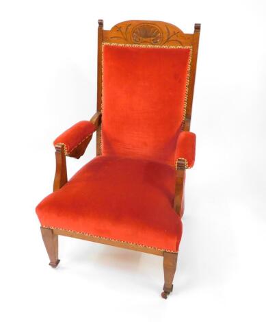 A Victorian lady's oak framed armchair upholstered in overstuffed red draylon, raised on tapering square legs, on castors.