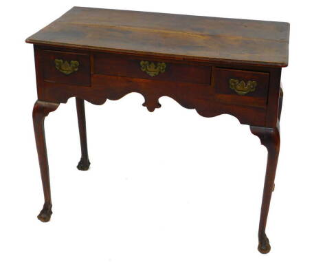 A Georgian mid 18thC oak and elm lowboy, with one long and two short deep drawers above a shaped frieze over cabriole legs and ball and claw feet, 86cm wide, 47cm deep, 73.5cm high.