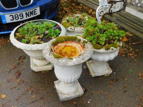 Three reconstituted stone garden urns, and a painted plastic garden vase. (4)