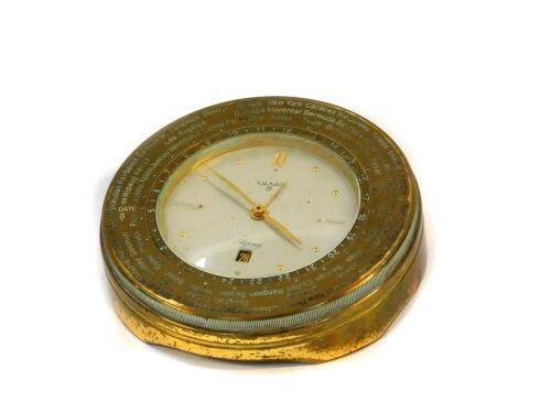 An Asprey Luxor brass cased world time clock, c1970s, circular silvered dial, centre seconds, date aperture, Swiss eight day movement, model 848, the circular case engraved with time zones of cities of the world, 11cm diameter.