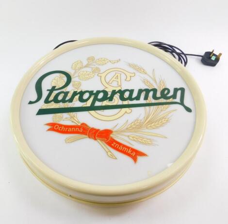 A Czech Staropramen advertising wall light, of circular form with a perspex front and cream plastic casing, 47cm diameter.