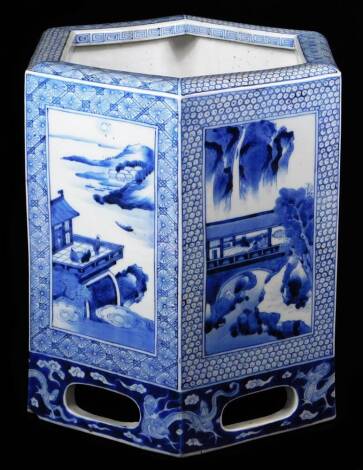 A Chinese Republic porcelain blue and white jardiniere, of hexagonal form, decorated with panels of scenes with figures and houses before mountains, on a part pierced base, unmarked, 27cm High.