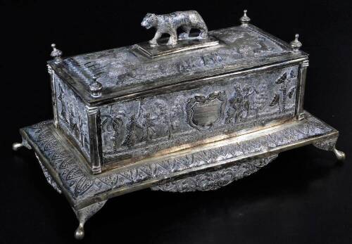 An early 20thC Indian ceremonial freedom casket, of rectangular form with tiger knop, urn finials and raised with various figures on elephants, trees and flowers, on a shaped base, with elongated orb feet and a shaped front apron repousse decorated with s