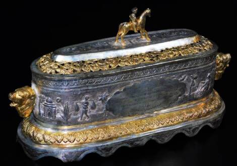 A highly elaborate Indian ceremonial freedom casket, of oval form, with horse and rider knop, flanked by lion mask handles, with a pierced arrangement of flower heads and scrolls, centred by a further arrangement of trees and buildings, on a shaped repeat