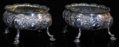 A pair of late 18thC silver salts, of oval form, heavily repousse decorated with a repeat floral pattern, on quadruple hoof feat, possibly 1795, marks badly rubbed, 9cm wide, 6oz. (2)