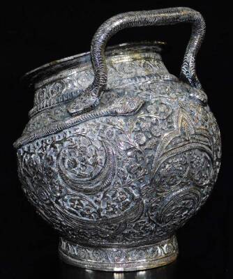 An early 20thC Indian four piece service, comprising shaped tea pot, sugar bowl and jug on an oval tray, each piece heavily repousse decorated with a repeat floral scroll pattern, the tray with an outer pierced border, 36cm wide. (4 pieces) - 12