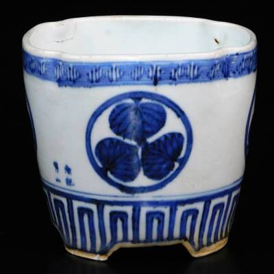 A lobed Japanese porcelain orchid pot, decorated with the Aoi mon of the Tokugawa family between key fret borders, signed illegibly to the side, 12.7cm high.