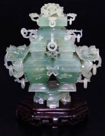 An elaborate Chinese green quartz quadruple vase, with four compartments and dragon head handles, with complex carved cover with dragon head and loose ring handles, wood base, tilled cloth covered box, early 20thC, 29cm wide. (boxed)