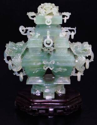 An elaborate Chinese green quartz quadruple vase, with four compartments and dragon head handles, with complex carved cover with dragon head and loose ring handles, wood base, tilled cloth covered box, early 20thC, 29cm wide. (boxed)