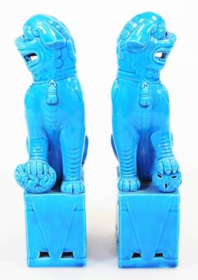 A pair of late 20thC Chinese dog of fo ornaments, in turquoise glaze on rectangular bases, each with their paw on a pierced ball, 26cm high. (2) - 2