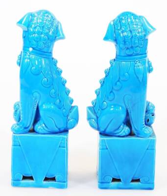 A pair of late 20thC Chinese dog of fo ornaments, in turquoise glaze on rectangular bases, each with their paw on a pierced ball, 26cm high. (2) - 3