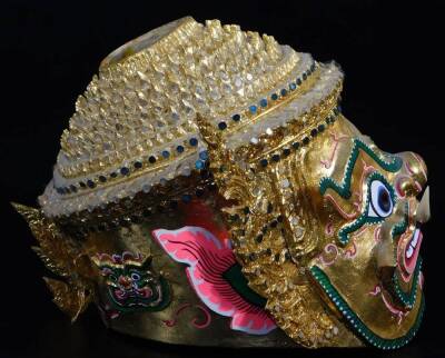 A Thai face mask, heavily decorated with mirrored glass sections set with tusks and with fierce facial expressions, 30cm high, and two others, etc. (a quantity) - 5