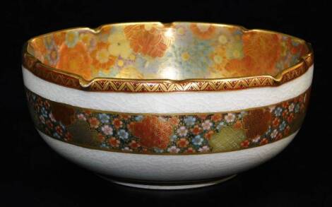 A Japanese Satsuma bowl, decorated with a dense mass of gilt and coloured flower heads to the interior, the exterior with a further band of flower heads, the base marked Nichiko Chikuzan below a Shimazu crest, late Meiji period, 14cm wide.