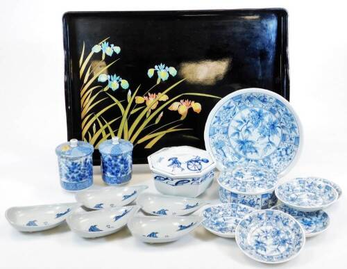 A late 20thC lacquered tray, decorated with flowers on a black ground with pierced handles, 47cm wide, a breakfast set comprising of a blue and white lidded jar, dish and five saucers, five various rice dishes, various other late blue and white, etc. (a