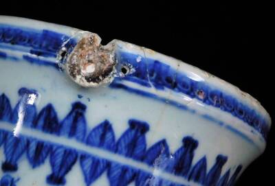 A 18thC blue and white porcelain ewer, with shaped spout, bellied circular body, inverted stem and domed foot, profusely decorated with vases of flowers in upper geometric pattern, with handle lacking, 25cm high. - 8