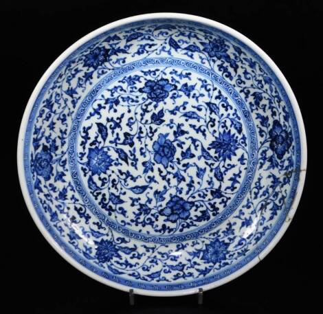 A late 18thC Chinese saucer dish, blue and white decorated (heavily repaired rim), 34cm diameter.