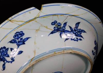 A 19thC Chinese porcelain Ming style charger, decorated in underglaze blue with bands of scrolling peonies wave border, the reverse with floral sprays and a six character double circle Yongzheng mark, probably 18thC, 45cm diameter. (heavily damaged) - 4