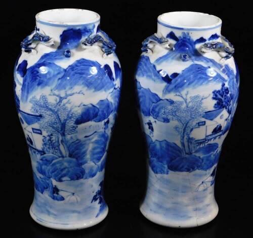 A pair of late 19thC Chinese porcelain baluster vases, the upper sections moulded with chitin (baby dragons), the main body decorated with fisherman, farmers, mountains and trees, four character Kangxi marks beneath, 25cm high. (2)