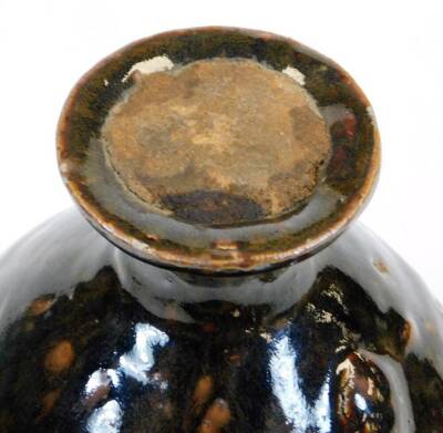 A West Country type glazed pottery bottle, of globular form, with a fixed seal to the neck, slip glazed overall with a brown splash decoration, 18cm high. - 3