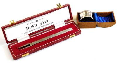 An Elizabeth II cased pickle fork, after the antique, Sheffield 1977, 18cm wide and a cased napkin ring, 2.4oz all in. (2)