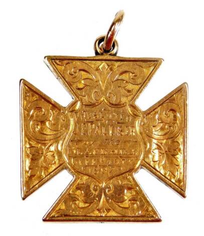 A Maltese cross pendant, marked J E Paluster by the Black Hill Glee Party 1897, partially etched with plain hook top, yellow metal, unmarked, 4cm high.