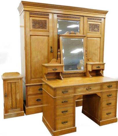 A late Victorian ash bedroom suite, by Roodhouse & Sons Leeds, comprising triple door wardrobe with moulded cornice, raised above a central section with drawers flanked by two openings, raised above an arrangement of drawers beneath, on a block base, 211c