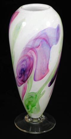 A 20thC studio Our Glass vase, predominantly in purple and green, on a cream ground, on a plain circular foot, signed, 27cm high.