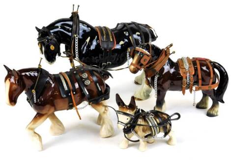 A 20thC pottery heavy horse, a Shire horse with leg raised in black and white colour way, leather type tack, 30cm high, two others, etc. (4)