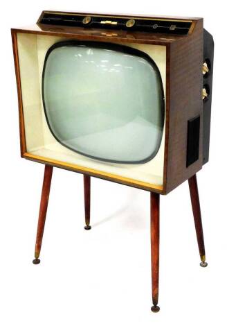 A vintage Defiant teak cased television, with 17 inch screen on turned legs terminating in compressed metal pads, 101cm high, 63cm wide, 34cm deep.