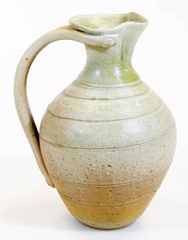 A 20thC Studio pottery ewer, with moulded lip, double handle and textured body, on circular foot, initialed TP, 24cm high.