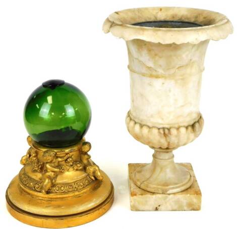 A marble centrepiece urn, of campana form with drop scroll border, partially gadrooned on a square base with liner, 37cm high (AF), a ships cast and wooden plinth base decorated with cherubs. (3, AF)