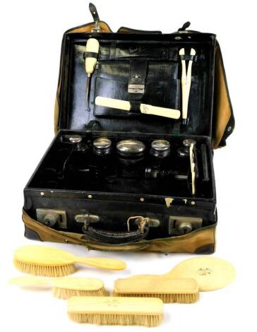 A late Victorian Drew and Sons Piccadilly travel case, of rectangular form with fitted interior containing a quantity of various silver topped jars, ivory handled part dressing table set, button hooks, thimble, vanity set, glove stretchers, etc., with pri