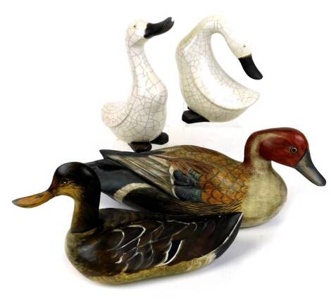 A Baja Indonesian painted decoy style duck, 40cm wide, another signed M Mackie' 86, two pottery duck ornaments. (4)