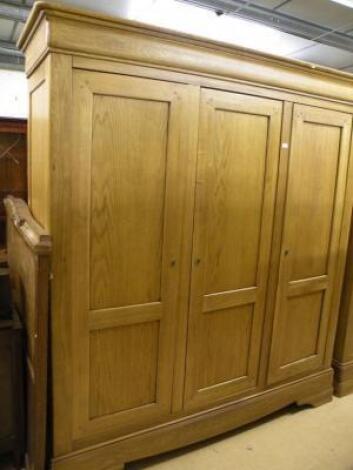 A French style oak triple wardrobe on bracket feet