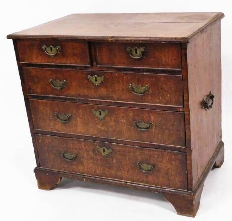 A George III style walnut chest, of two short and three long graduated cock beaded drawers, each with plate back swan handles, the quarter veneer top with a wide cross banding, each drawer with a herringbone inlay, on stylised bracket feet, 75cm high, 68c