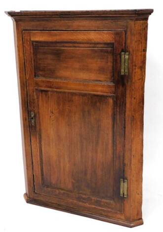 An 18thC oak hanging corner cupboard, with two panelled door on a moulded base, 109cm high, 79cm wide, 42cm deep.