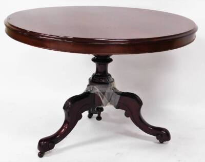 A Victorian mahogany tilt top table, the circular top with moulded outline on a heavily carved baluster column terminating in triple cabriole legs with carved floral emblem and scroll feet terminating in castors, when raised 135cm high, 100cm diameter.