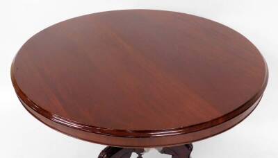 A Victorian mahogany tilt top table, the circular top with moulded outline on a heavily carved baluster column terminating in triple cabriole legs with carved floral emblem and scroll feet terminating in castors, when raised 135cm high, 100cm diameter. - 2