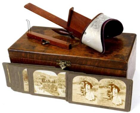 An early 20thC stereoscopic viewer, with a number of cards in oak case, cards to include Before The Wedding, etc., the case 38cm wide.