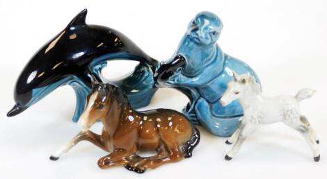 A Beswick foal, number 915, recumbent, 13cm wide, a grey foal, Poole dolphin and an otter, marked beneath. (4)