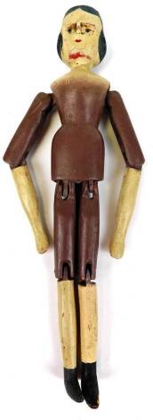 An 18thC style wooden peg doll, with articulated limbs, sparsely decorated, 31cm high.