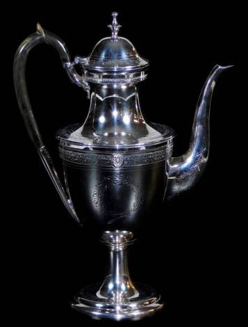 An early 20thC silver plated coffee pot, with compressed dome lid, heavily chased with garlands and scrolls, with decorative thumb mould handle and spout on an inverted stem and circular foot, 35cm high.