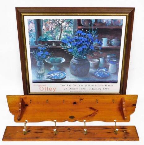 A set of pine backed pegs, each brass with porcelain mounts, 103cm wide, and a Margaret Olley retrospective art gallery print, in stained beech frame. (3)