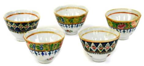 Five similar early 20thC Oriental tea bowls, polychrome decorated with a floral border to each, 6cm diameter. (5)