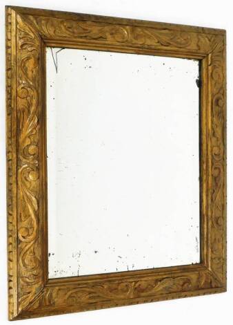 An early 20thC carved oak mirror, of rectangular form, with bevel glass, the border set with scrolls and acanthus leaves, 60cm x 50cm.