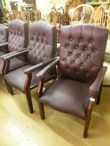 A set of three burgundy upholstered office type chairs