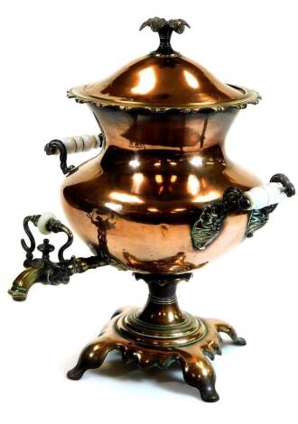 A Victorian copper and brass samovar, of shaped bellied form on an inverted stem and platform base, flanked by porcelain handles with a front tap set with a porcelain stopper, the whole surmounted by compressed flower head knop, 53cm high.