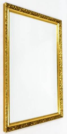 A rectangular gilt mirror, with inner bead and outer floral border, with bevel glass, 121cm high, 84cm wide.