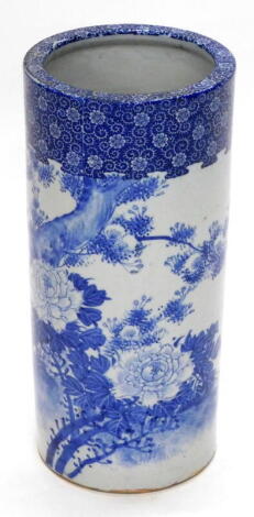 A late 19th/early 20thC Japanese blue and white cylindrical umbrella stand, decorated overall with flowers, birds, etc., 45cm high.